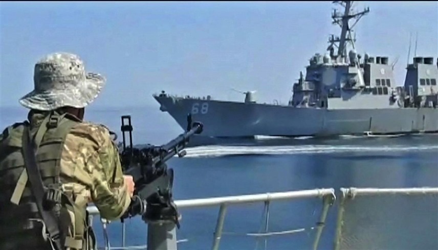 سفن حربية إيرانية تواجه سفينة حربية أمريكية (أ ف ب)