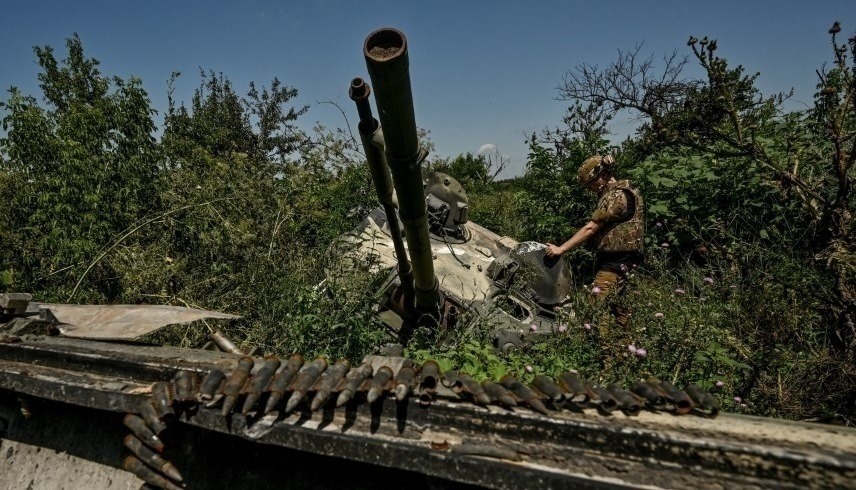 جندي أوكراني يتفقد دبابة روسية مدمرة (رويترز)
