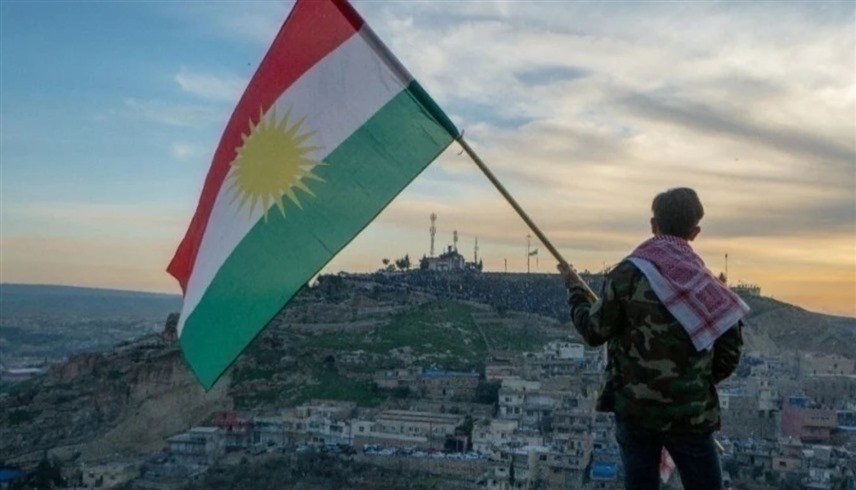 مقاتل يحمل علم كردستان العراق