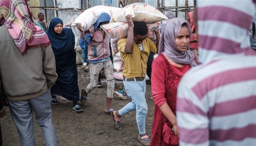 إثيوبيون يحملون مساعدات غذائية في أمهرة (أ ف ب)
