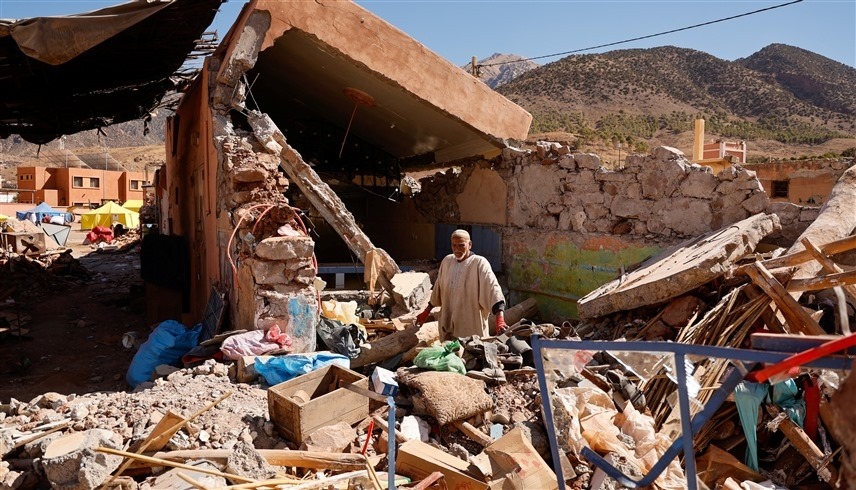 مواطن مغربي يتجول بين أنقاض منزله المدمر جراء الزلزال في المغرب (رويترز)