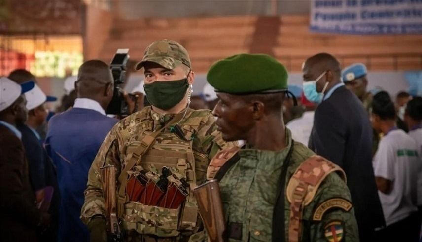 عنصر من مجموعة "فاغنر" يقف إلى جانب جندي من جمهورية أفريقيا الوسطى (أ ف ب)