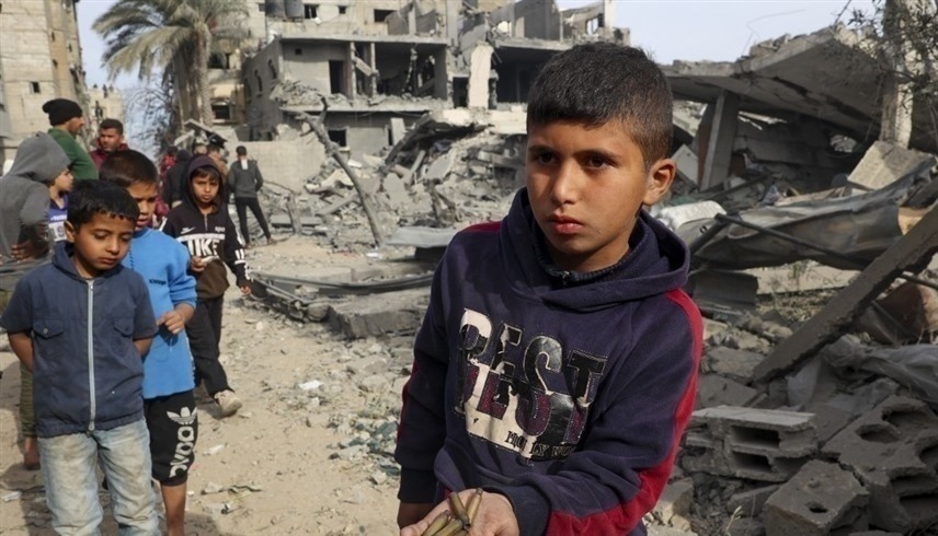 فتى فلسطيني يحمل رصاصات فارغة في حي مدمر في رفح