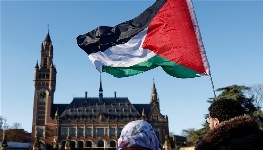 متضامن مع غزة يرفع علم فلسطين أمام محكمة العدل الدولية (وكالات)