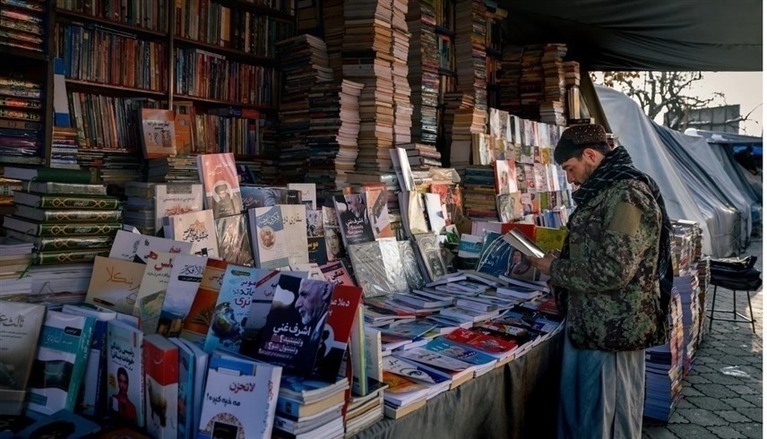 مقاتل من طاليان أمام كشك لبيع الكتب.