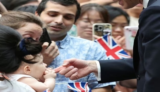 طفلة تعض إصبع الأمير ويليام وهو يحيي الحشود في سنغافورة